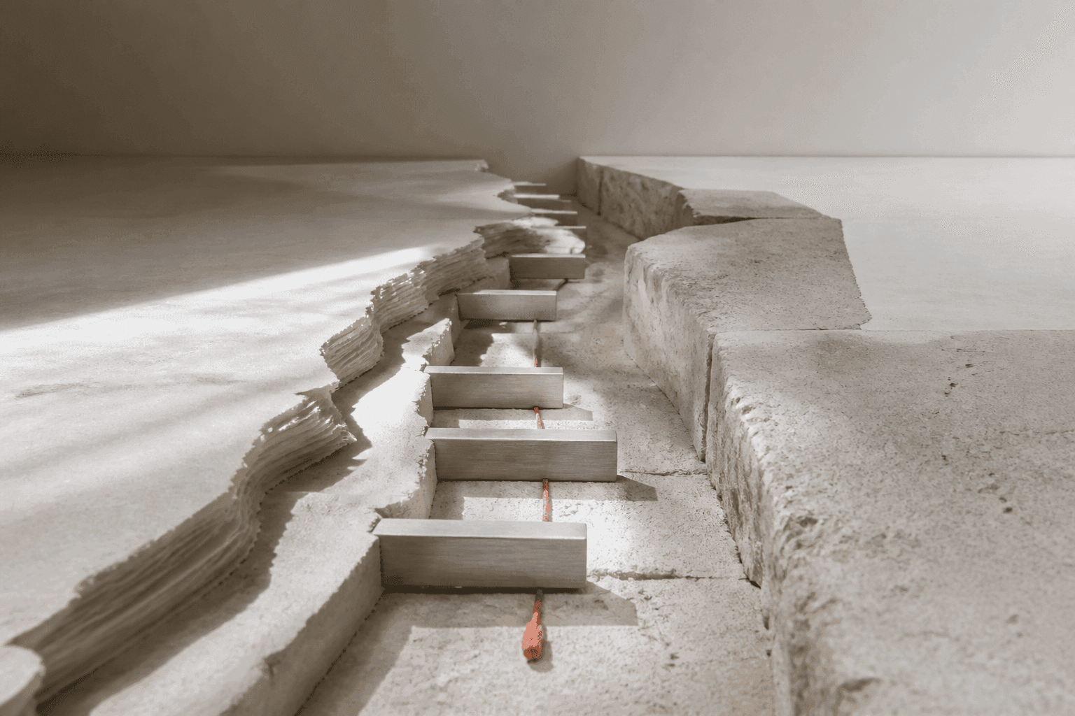 Generated still life showing a deep zigzag channel cut through layers of ivory paper and plaster, crossed by small aluminium pieces and a single coral-resin accent.