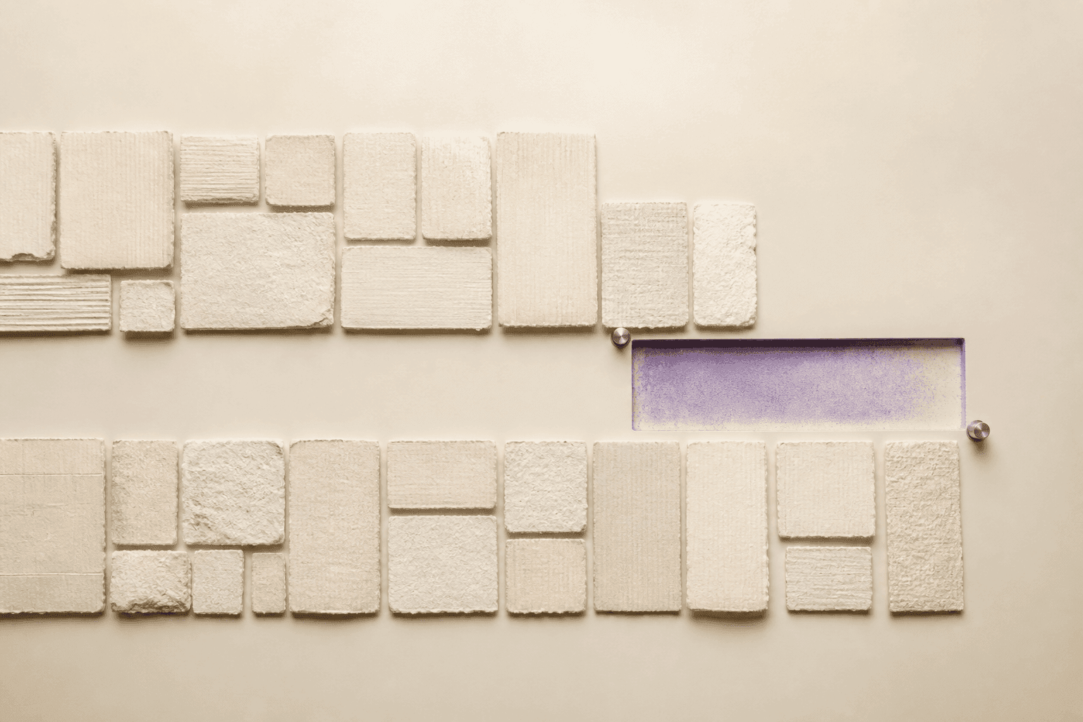 Illustration générée en vue zénithale montrant deux rangées de carreaux ivoire en papier et plâtre interrompues par une empreinte rectangulaire violette vide, bordée de deux repères métalliques.